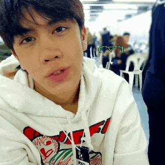 a young man wearing a white hoodie with a red and green graphic on the front
