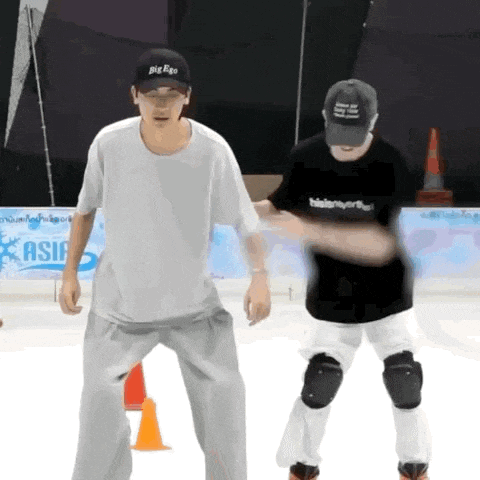 a man wearing a big bang hat stands next to another man wearing a black shirt