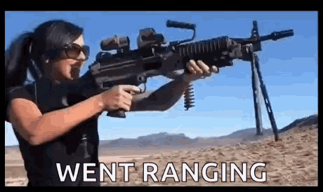 a woman is holding a machine gun in the desert with the words `` went ranging '' written below her .