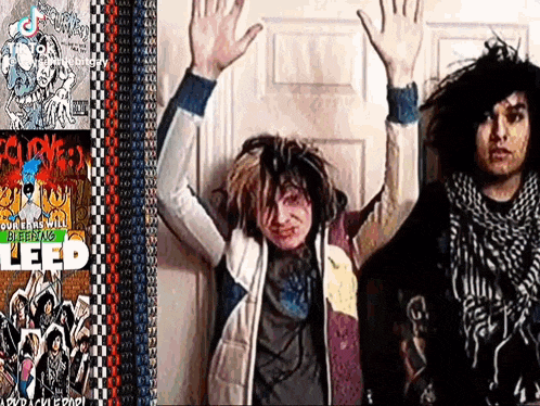 two people are standing next to each other with their hands in the air .