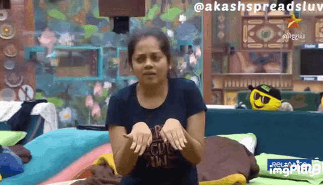 a woman wearing a black shirt that says ' akashspreadsluv ' on the bottom