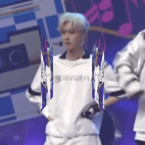 a man in a white shirt is standing on a stage holding a piece of paper in his hand .