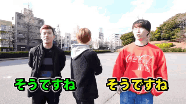 a man wearing a red coca cola sweatshirt stands next to another man