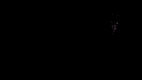 a person is smoking an electronic cigarette in a dark room .