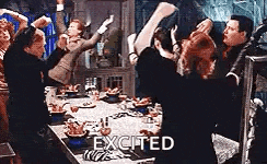 a group of people are standing around a table with their arms in the air and the word excited written on the bottom .