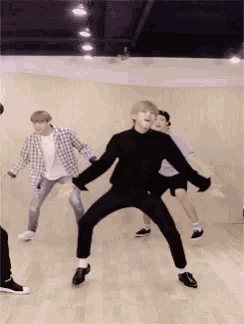 a group of young men are dancing in a room .