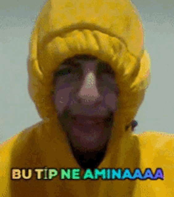 a man wearing a yellow hooded jacket with the words butip ne aminaaa on the bottom