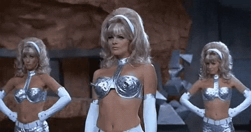three women in silver costumes are standing next to each other .