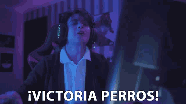 a man wearing headphones says victoria perros in front of a computer
