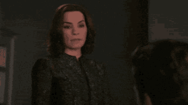 a woman in a black jacket is smiling at a man .