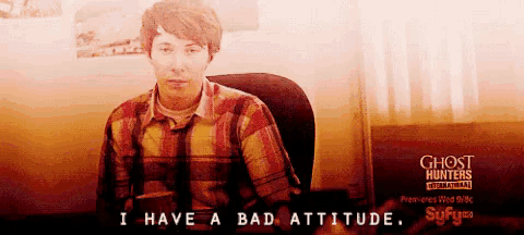 a man in a plaid shirt sits in a chair with the words i have a bad attitude written below him