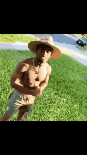 a shirtless man wearing a cowboy hat and shorts