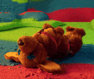a stuffed animal is laying on its back in a rainbow colored room