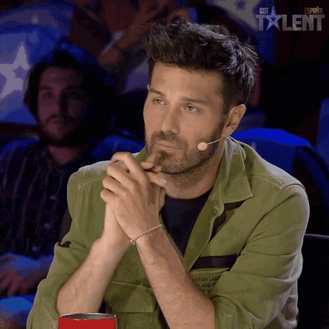 a man sitting in front of a microphone with the word talent on the bottom right