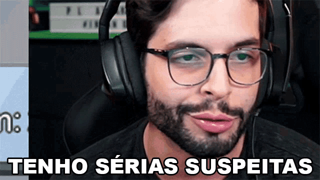 a man wearing glasses and headphones says " tenho serias suspeitas "