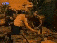 a man in a tank top is standing next to a man in a black shirt .