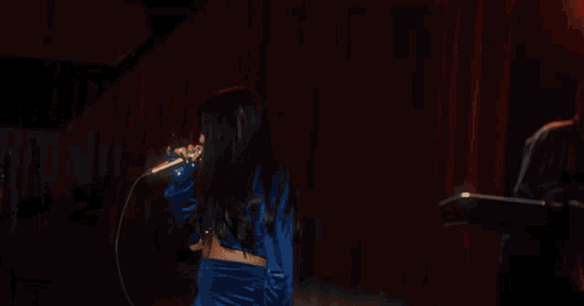 a woman singing on stage in front of a sign that says " u "