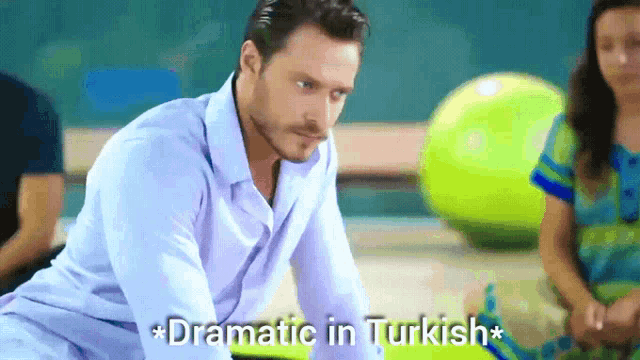 a man in a blue shirt says dramatic in turkish on the bottom