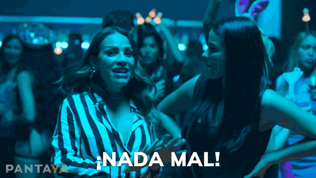 a woman in a striped shirt is standing next to another woman in a black dress and the words nada mal are above them