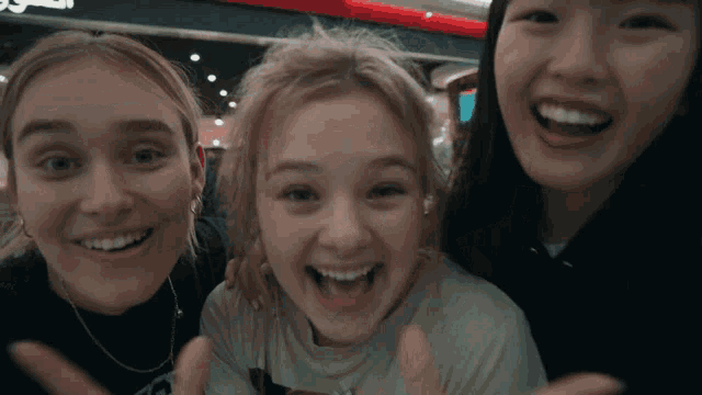 three girls are posing for a picture and one of them is wearing a t-shirt that says ' i love you '