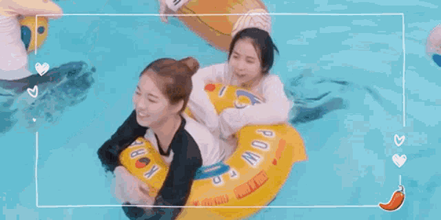two women are riding a yellow raft in a swimming pool .