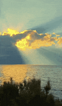 the sun shines brightly through the clouds over the ocean