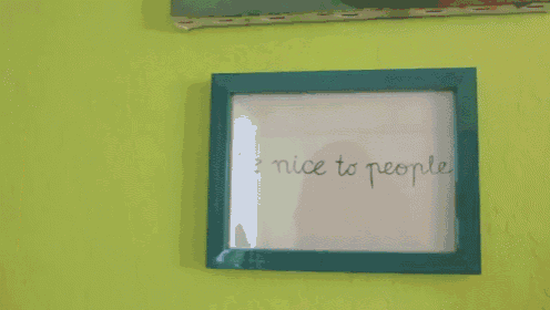 a painting is hanging on a yellow wall next to a blue frame