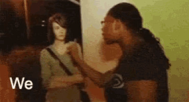 a man and a woman are standing next to each other and the man is holding the woman 's arm .