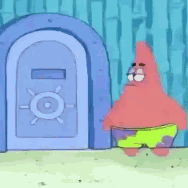 patrick star from spongebob squarepants is standing in front of a safe door .