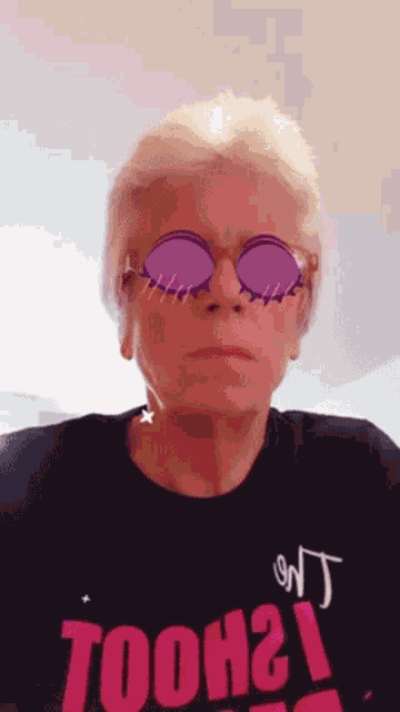 a woman wearing sunglasses and a shirt that says tooh2