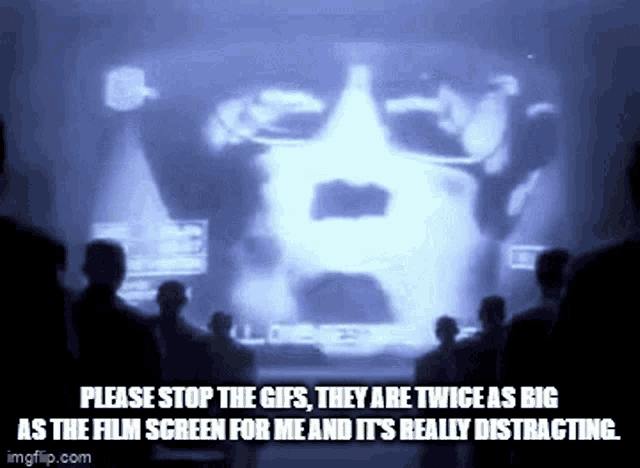 a group of people are standing in front of a screen with a picture of a man 's face on it .