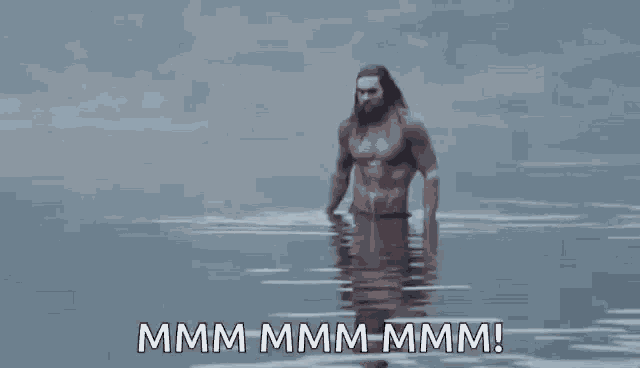 a shirtless man is standing in the water with the words `` mmmm mmmm mmmm ! ''
