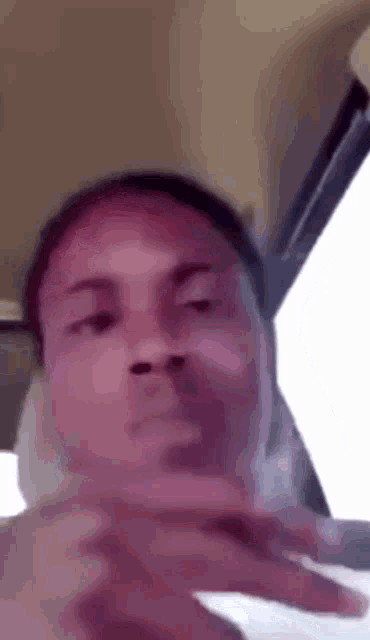 a man is making a funny face in a car while smoking a cigarette .