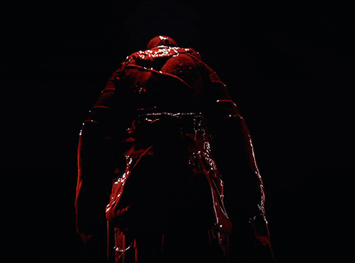 a person in a dark room with red lights behind them