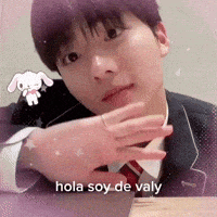 a man in a suit and tie is sitting at a table and says hola soy de valy