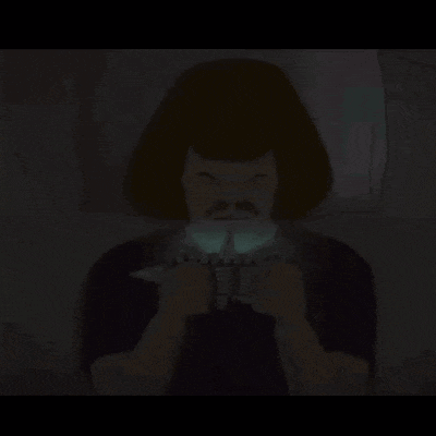 a man with a mustache is holding a controller in his hands in the dark