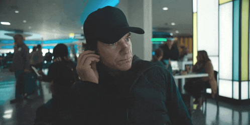 a man wearing a black hat is talking on his cell phone