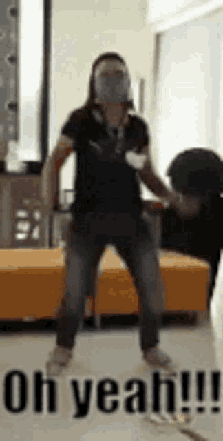 a man wearing a mask is dancing in a room with the words `` oh yeah !!! '' written on the bottom .