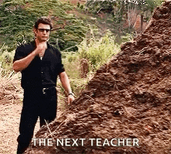 a man in a black shirt is standing next to a pile of dirt and says `` the next teacher '' .