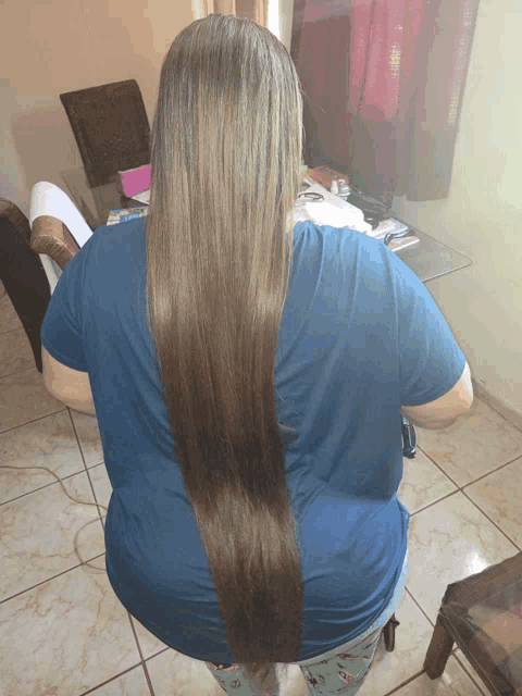 a woman with very long hair is sitting on a chair