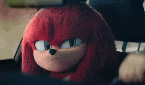 a stuffed animal with red hair is sitting in a car seat