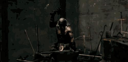 a man with a beard is sitting on an anvil with sparks coming out of it