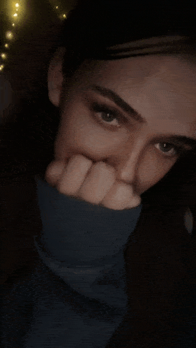 a close up of a woman covering her face with her hands