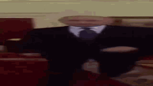 a man in a suit and tie is walking on a red carpet .