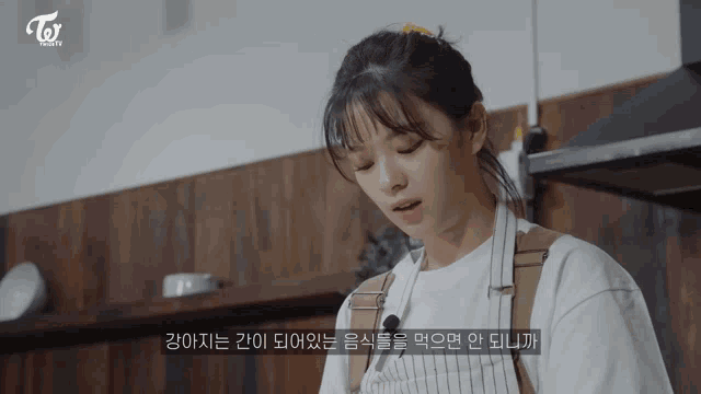 a woman wearing an apron is cooking in a kitchen with a twice logo in the background