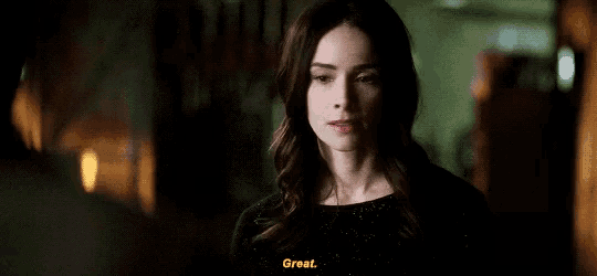 a woman in a black dress is smiling and talking .