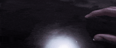 a person is holding a flashlight in the dark and it is shining brightly .