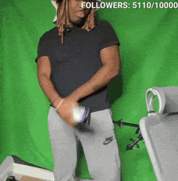a man wearing a black shirt and grey nike sweatpants