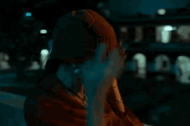 a woman in a beanie is holding her head in her hands .