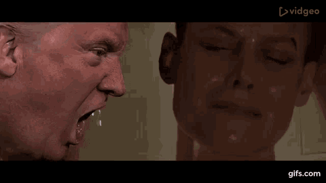 a man and a woman are standing next to each other in a bathroom and the man is screaming at the woman .